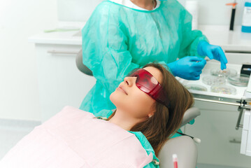 Blonde young woman waits patiently for the treatment at the dentist to begin.