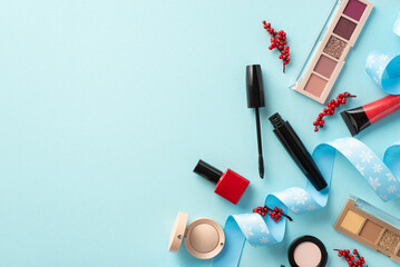 Christmas shopping concept. Top view photo of decorative cosmetics eyeshadow palettes red nail polish mascara lip gloss mistletoe berries curly ribbon on isolated pastel blue background with copyspace