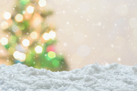 Empty white snow with blur Christmas tree with bokeh light background