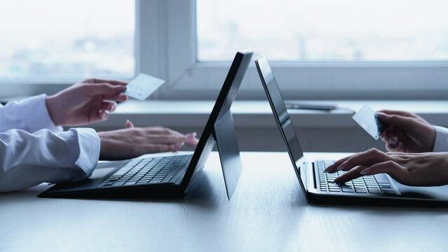 Online banking. Electronic transaction. E-commerce transfer. Unrecognizable female office workers hands using credit card laptop for cashless payment at workplace.