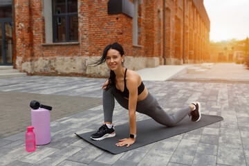 Pretty fitness woman doing stretching exercise on the street