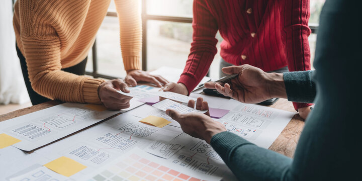 UI UX creative designer team designing wireframe layout for responsive mobile smartphone application in office