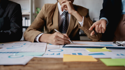 Meeting of hardworking businesspeople work together as a team by presenting graphs. and charting the work of each department, presenting and discussing the report together in the meeting.