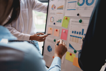 Meeting of hardworking businesspeople work together as a team by presenting graphs. and charting the work of each department, presenting and discussing the report together in the meeting.