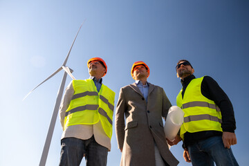 Wind turbines operate behind specialists of maintenance. Senior engineer and technicians look...