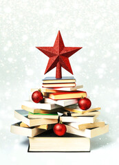 Christmas concept background. Books in the form of a christmas tree with christmas balls and red...