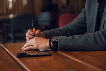 Anonymous man taking notes in notepad