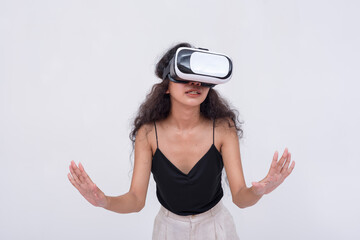 A young asian woman explores a VR environment via a virtual reality headset. Isolated on a white backdrop.