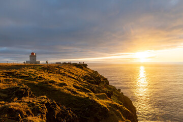 lighthouse at a cliff in the sunset