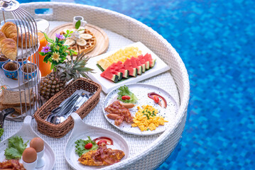 Fototapeta na wymiar Breakfast in swimming pool, floating breakfast in villa resort. relaxing in calm pool water, healthy breakfast and tropical fruit.
