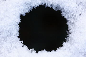Close-up of icy snow texture make round frame or border for abstract winter background