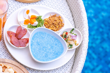 Breakfast in swimming pool, floating breakfast in villa resort. relaxing in calm pool water, healthy breakfast and tropical fruit.