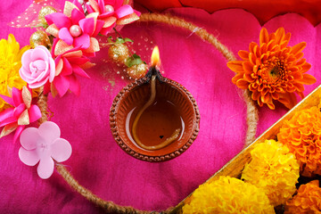 Happy Diwali, Clay Diya lamps lit during Diwali, Hindu festival of lights. Colorful traditional oil lamp diya, flower decoration.