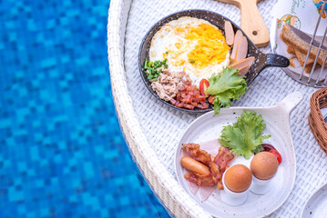 Breakfast in swimming pool, floating breakfast in villa resort. relaxing in calm pool water, healthy breakfast and tropical fruit.