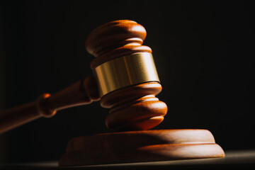 Justice and law concept.Male judge in a courtroom with the gavel, working with, computer and docking keyboard, eyeglasses, on table in morning light