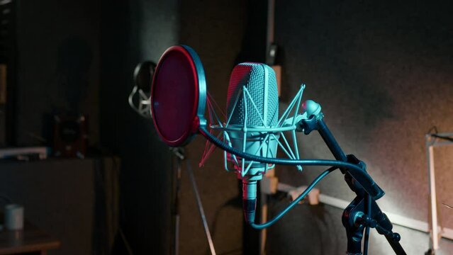 Professional microphone, speakers are in dark recording hall. Sound department with musical equipment. Audio studio for radio broadcast, production of hit songs, phonogram, singer albums