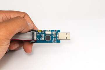 An AVR microcontroller USB downloader held in one hand.