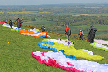 Paragliders preparing their wings on a hill