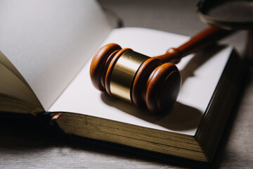 Justice and law concept.Male judge in a courtroom with the gavel, working with, computer and docking keyboard, eyeglasses, on table in morning light