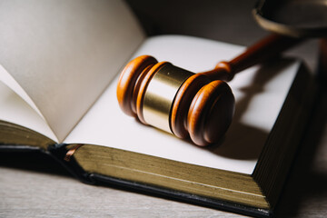 Justice and law concept.Male judge in a courtroom with the gavel, working with, computer and docking keyboard, eyeglasses, on table in morning light