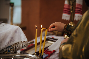 the priest lights a candle in the church