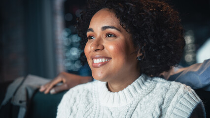 African American Happy Woman Enjoying Movie Streaming Service and Laughing Out Loud While Relaxing...