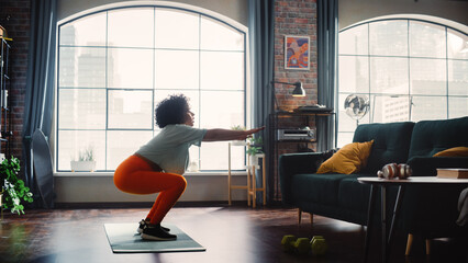 Side View of Black Fit Girl Doing Sport Exercises in Bright and Spacious Loft Style Room. Female...