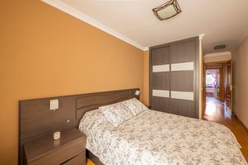 bedroom with brown wooden furniture with matching bedside tables and a built-in wardrobe with...