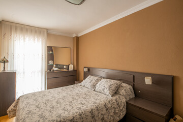 bedroom with double bed with dark wood furniture and balcony with curtains