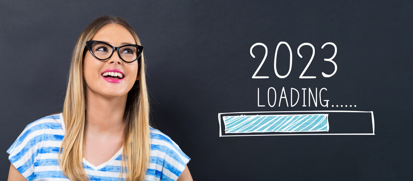 Loading new year 2023 with happy young woman in front of a blackboard
