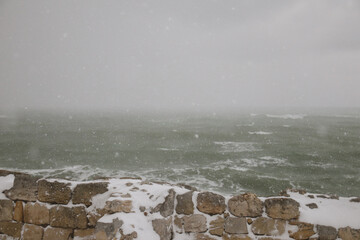 Stormy sea and snowy landscape
