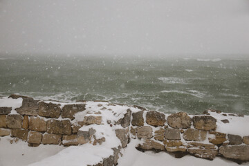 Stormy sea and snowy landscape