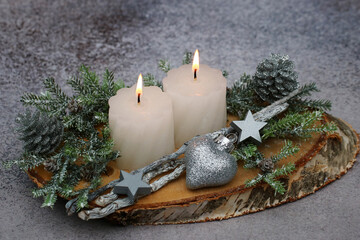  Kerzen mit Tannenzweigen und Weihnachtsschmuck auf einer Baumscheibe dekoriert.