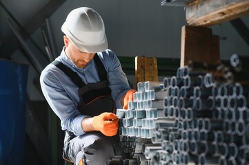 Male factory mechanics or Engineer in safety uniforms are working on metal drilling machines in...