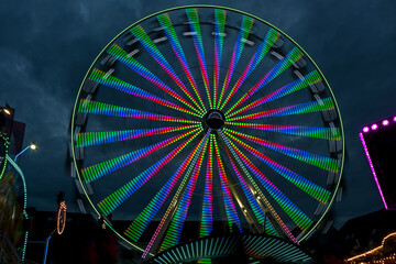 Long exposure of a giant wheel in motion with colorful lights at a christmas fair against a cloudy...