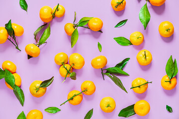 Tangerines with leaves on a lilac background.