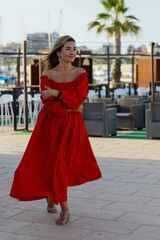 Obraz premium Stylish beautiful woman in a red dress in a cafe