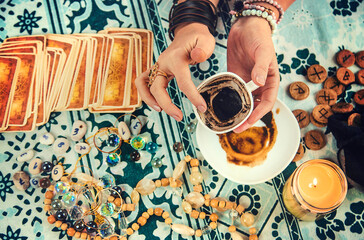 A fortune teller reads fortunes on coffee grounds. Selective focus.