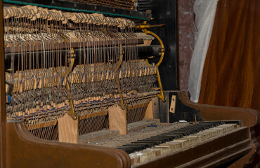 Stare , zabytkowe i zdewastowane pianino . Anatomia pianina - widoczna wewnętrzna budowa strunowego instrumentu .