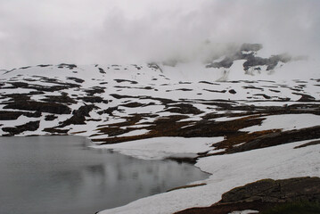 Snowy landscape with some rocks and a lake