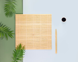 Minimalistic, oriental style composition with nature bamboo mat, wooden chopsticks and palm leaves. Eco friendly Mock up for display or montage of dishes or food. Showcase for presentation. Flat lay