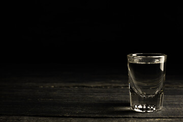 Ukrainian gorilka or vodka or tequila or rum (transparent highly alcoholic drink) shot on dark background.