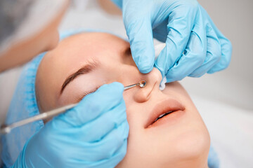 woman during a mechanical face cleansing procedure