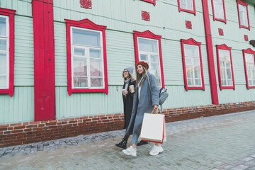 Happy female friends shopping. Two beautiful young women enjoying shopping in city with shopping bags copy space - consumerism and friendship concept