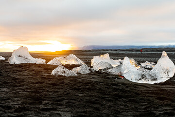 Ice chunks at black beach in sunset