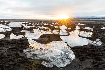 Ice chunks at black beach in sunset