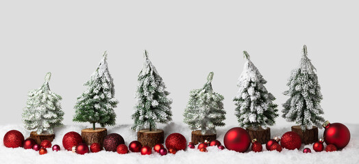 Christmas background in winter, snow landscape. Christmas trees with red Xmas decoration in row, panorama, banner with copy space