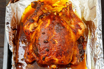 Whole chicken baked in soy sauce and spices in foil.