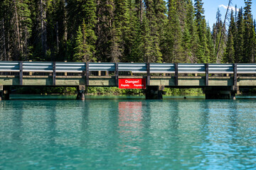 Fototapeta na wymiar Danger Rapids sign near the bridge at Emerald Lake in Yoho National Park Canada