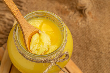ghee oil. Ghee or clarified butter in jar on a wooden background. banner, menu, recipe place for text